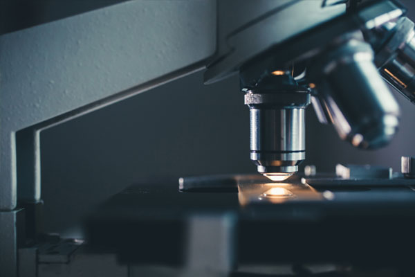 Close-up shot of microscope with metal lens at laboratory.